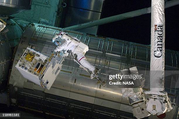 In this handout image provided by the National Aeronautics and Space Administration , NASA astronaut Ronald Garan attached to the robotic arm...