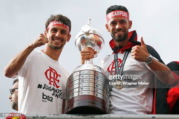 Rodrigo Caio and Pablo Mari of Flamengo pose with the trophy on a bus during the celebrations the day after Flamengo won the Copa CONMEBOL...