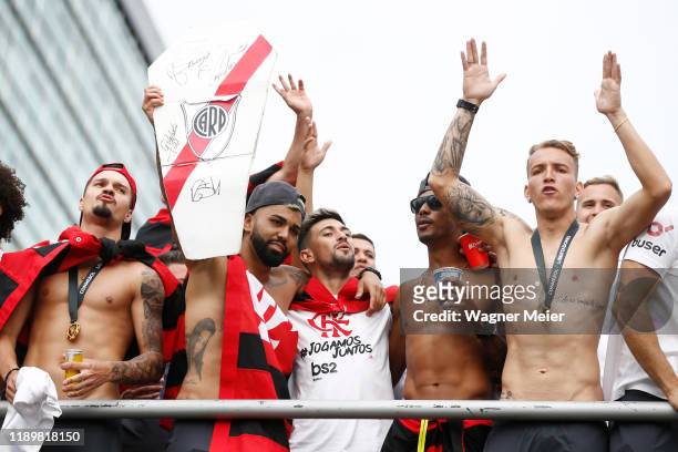 Gabriel Barbosa of Flamengo holds a banner of River Plate on a bus with teammates during the celebrations the day after Flamengo won the Copa...