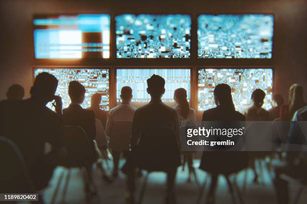 gruppo di persone che guardano più televisori contemporaneamente - mass media foto e immagini stock