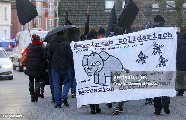 December 2019, Lower Saxony, Buxtehude: Participants in a small demonstration walk through the city centre of Buxtehude with a banner with the...
