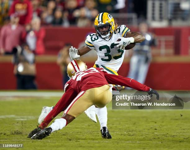 Running back Aaron Jones of the Green Bay Packers carries the ball as cornerback Ahkello Witherspoon of the San Francisco 49ers defends during the...