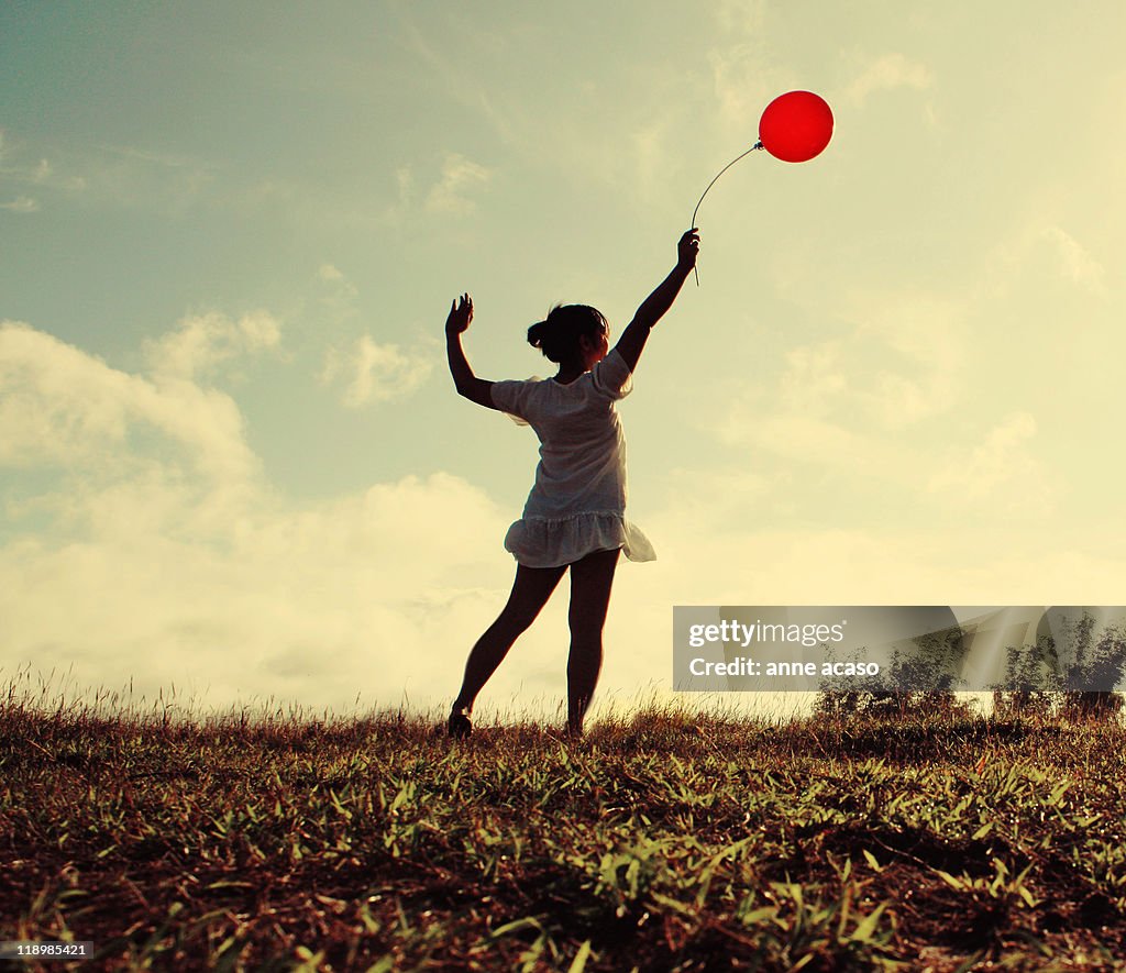 Girl holding red balloon