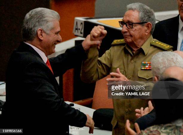 Cuban First Secretary of the Communist Party Raul Castro and Cuban President Miguel Diaz Canel raise their hands during the closing of the Fourth...