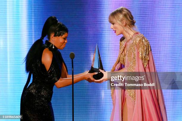 Regina King presents Taylor Swift with the Artist of the Year award onstage during the 2019 American Music Awards at Microsoft Theater on November...