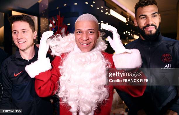 Paris Saint-Germain's French forward Kylian MBappe dressed as Santa Claus Paris Saint-Germain's Spanish midfielder Ander Herrera and Paris...
