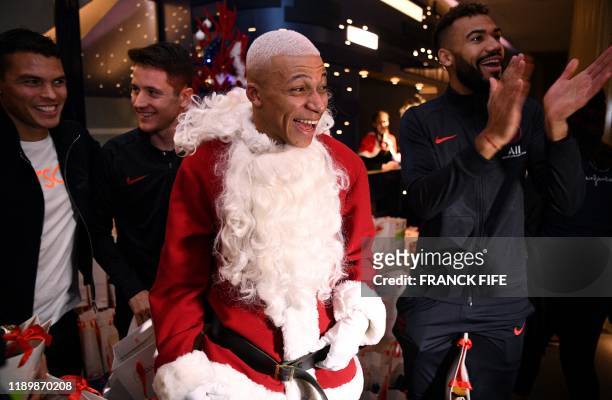 Paris Saint-Germain's French forward Kylian MBappe dressed as Santa Claus, Paris Saint-Germain's Brazilian defender Thiago Silva , Paris...