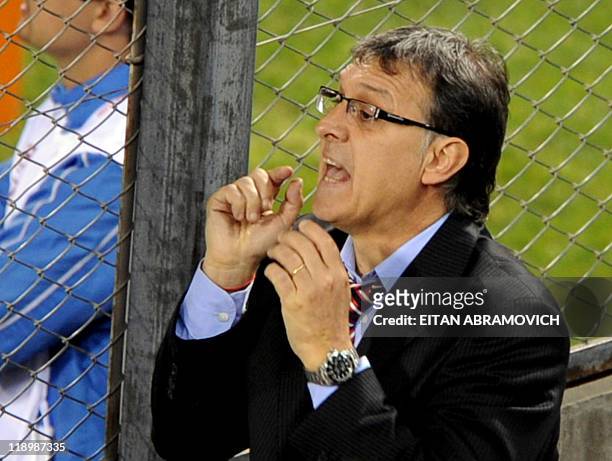 Paraguay's head coach Gerardo Martino gives instructions to his players from behind a fence, during the 2011 Copa America Group B first round...