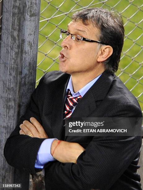 Paraguay's head coach Gerardo Martino gives instructions to his players from behind a fence, during the 2011 Copa America Group B first round...