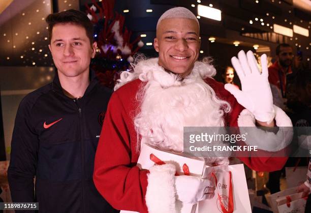 Paris Saint-Germain's Spanish midfielder Ander Herrera and Paris Saint-Germain's French forward Kylian MBappe dressed as Santa Claus pose for a...