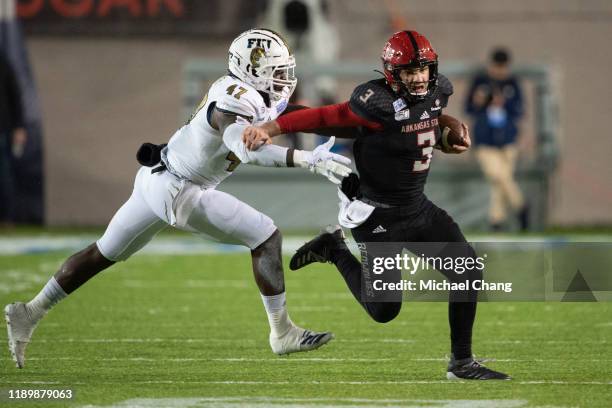 Quarterback Layne Hatcher of the Arkansas State Red Wolves looks to run the ball by linebacker Chris Whittaker of the FIU Golden Panthers in the...