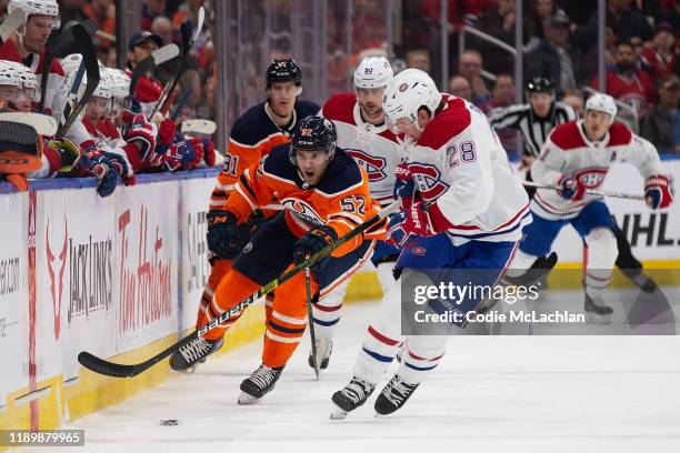 Patrick Russell of the Edmonton Oilers moves the puck past Mike Reilly of the Montreal Canadiens at Rogers Place on December 21 in Edmonton, Canada.