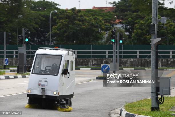 This photograph taken on December 5, 2019 shows an autonomous road sweeper operating during a trial test at the Centre of Excellence for Testing &...