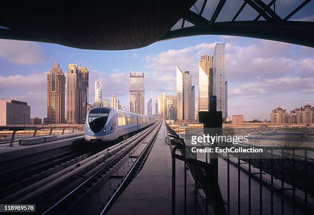 arrival of metro at a modern business district - dubai metro stock pictures, royalty-free photos & images