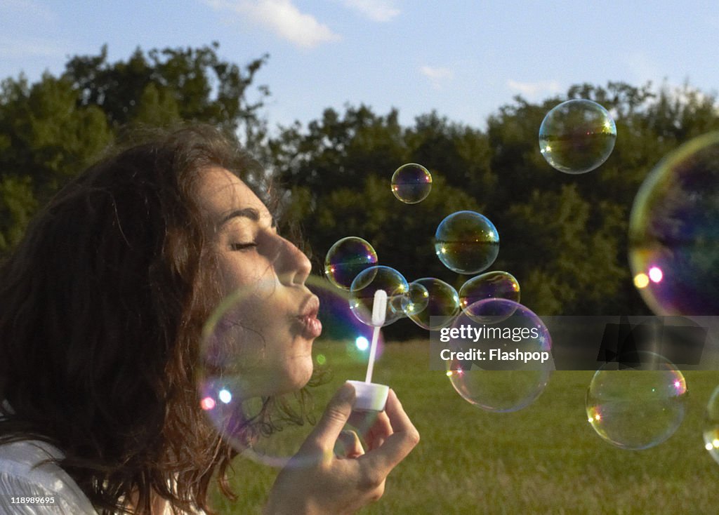 Portrait of woman blowing bubbles