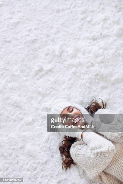 meisje liggend op de sneeuw - face snow stockfoto's en -beelden