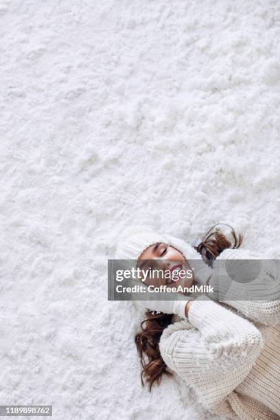 girl lying down on the snow - beautiful nature face stock pictures, royalty-free photos & images