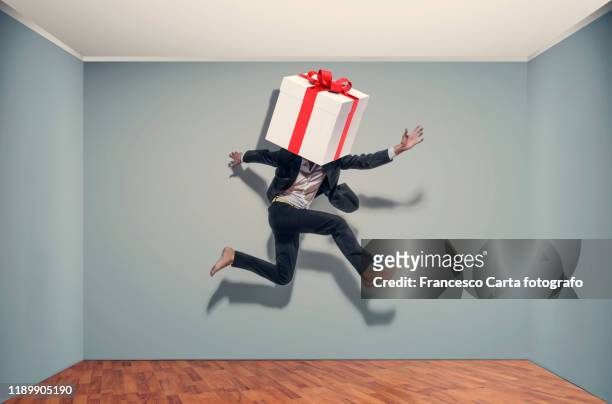 businessman with a large gift package - funny christmas gift fotografías e imágenes de stock