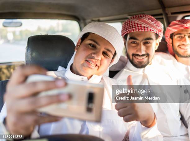 arab boys traveling and taking selfie - saudi youth stock-fotos und bilder