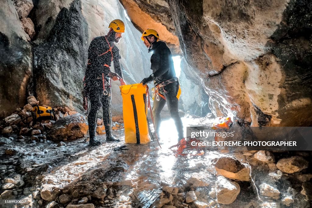 Twee canyoneers verpakken hun statische touw in een waterdichte gele tas aan de onderkant van de Canyon