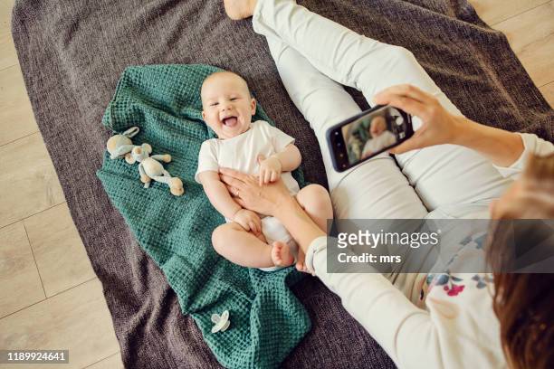 mother and baby - baby smartphone stock pictures, royalty-free photos & images