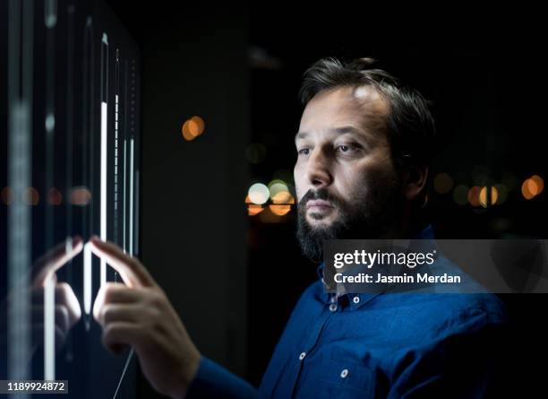 man sliding on smart home controllers - young businessman using a virtual screen stockfoto's en -beelden