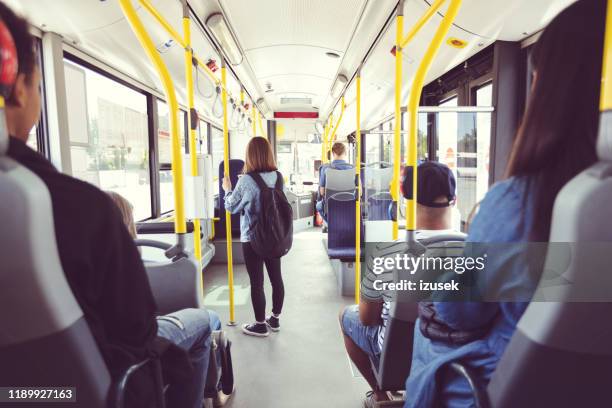 hombres y mujeres que viajan diariamente en transporte público - autobus fotografías e imágenes de stock