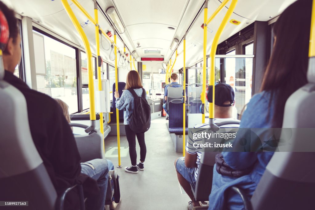 Uomini e donne che si spostano con i mezzi pubblici
