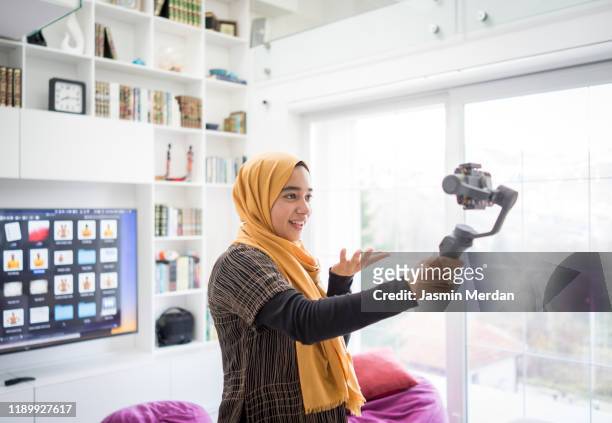 arab girl demonstrating hijab fashion online using steady cam with smartphone - fashion show bildbanksfoton och bilder