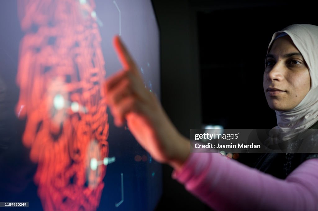 Muslim woman working on futuristic screen