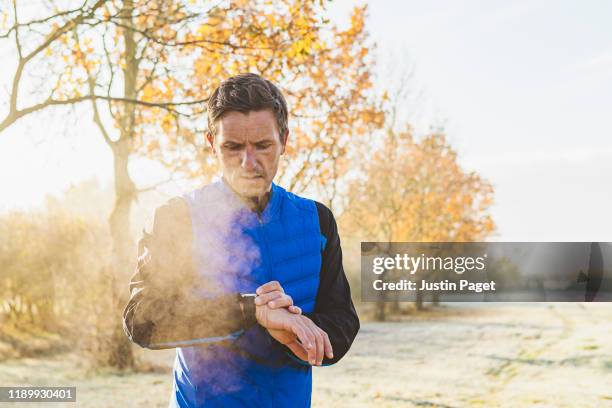 runner using smart watch - cold temperature stock pictures, royalty-free photos & images