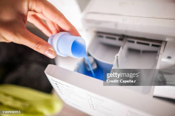 maison - verser du liquide pour le lave-linge - washing machine stock pictures, royalty-free photos & images