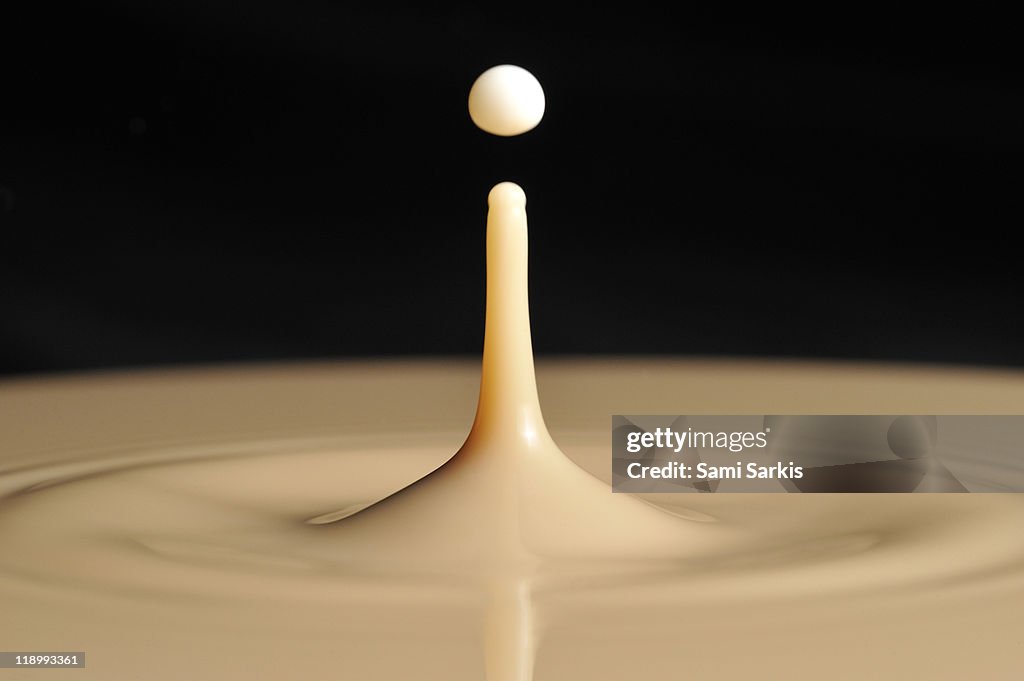 Drop of milk splashing into coffee