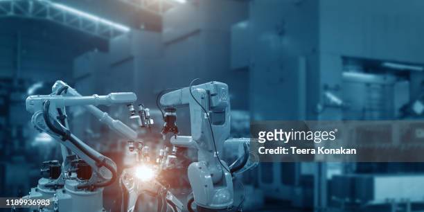 automatic welding robot mechanical arm is working in the modern automobile parts factory. - computer aided manufacturing stock pictures, royalty-free photos & images