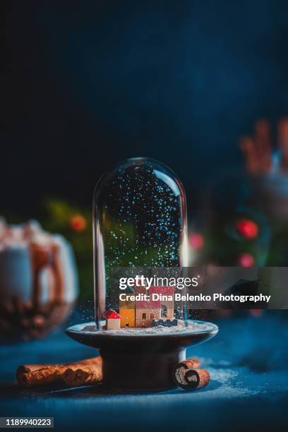 christmas miniature town under snow in a glass dome. creative still life with copy space - magie de noel stockfoto's en -beelden