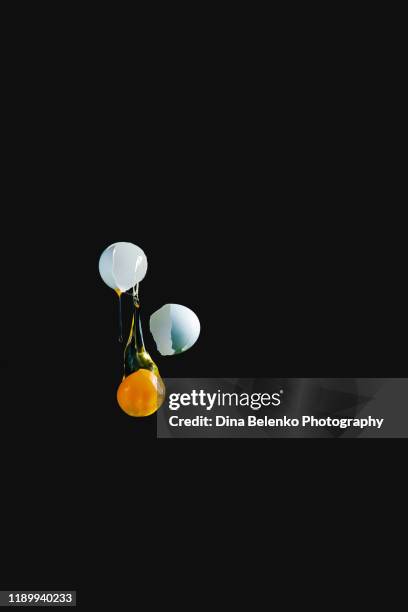 flying yolk on black background, high-speed food photography - gema de ovo imagens e fotografias de stock