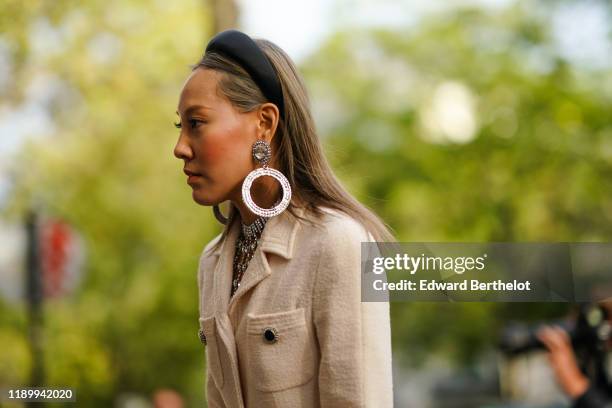 Guest wears a headband, a large circular bejeweled earrings, a jacket, outside Alessandra Rich, during Paris Fashion Week - Womenswear Spring Summer...