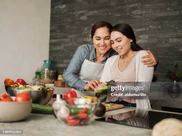 liebende lateinische mutter lehrt tochter zu hause zu kochen - mutter tochter küche stock-fotos und bilder