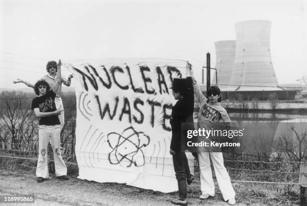 Four anti-nuclear power protestors stand holding a banner reading 'nuclear waste' on Three Mile Island near Harrisburg, Pennsylvania, USA, 1979. 1979...