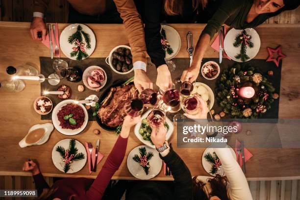 overhead-ansicht von freunden, die traditionelles weihnachtsessen essen - weihnachtsessen stock-fotos und bilder