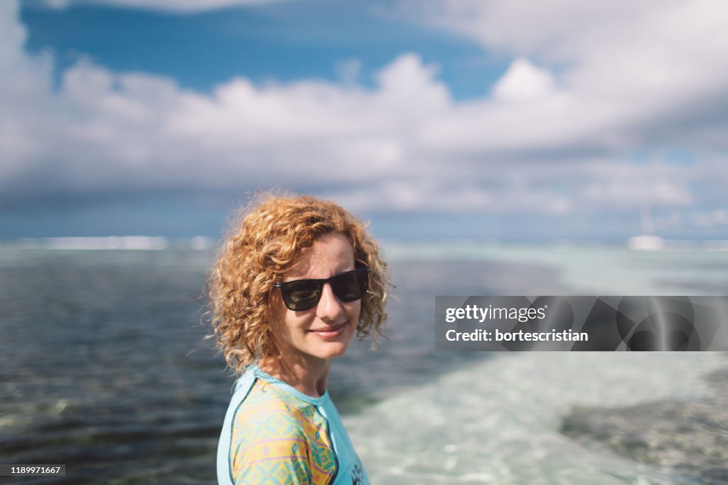 Retrato da mulher em pé na praia
