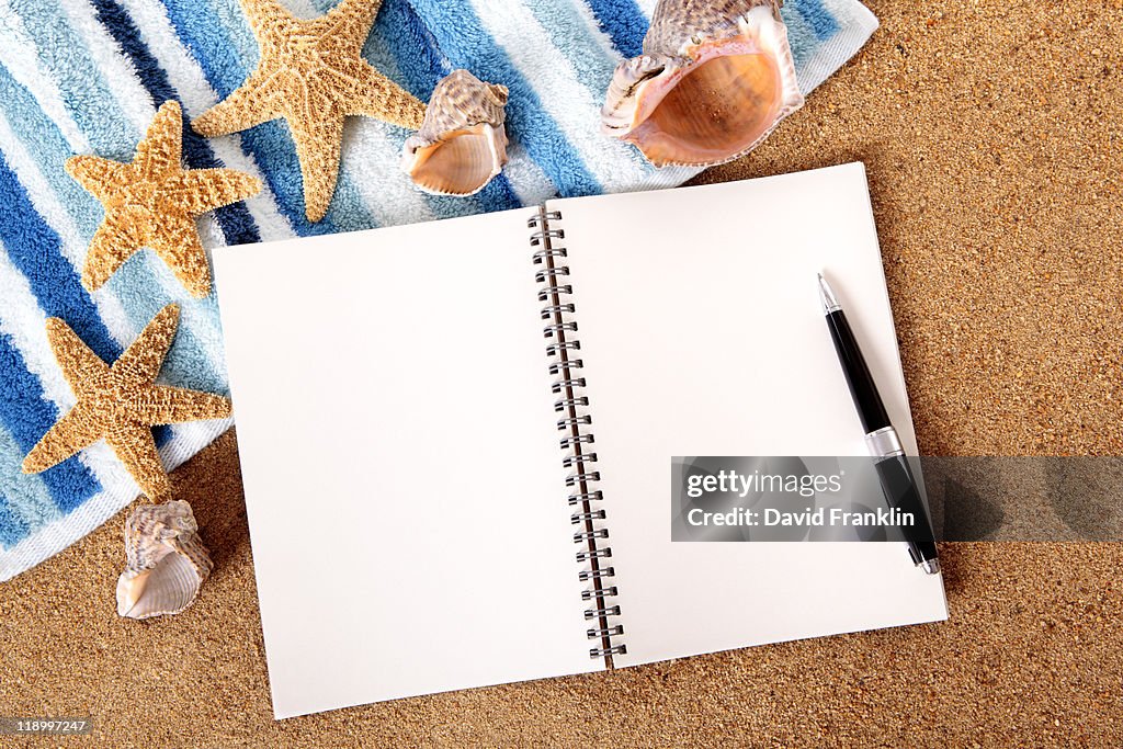 Beach scene with blank writing book