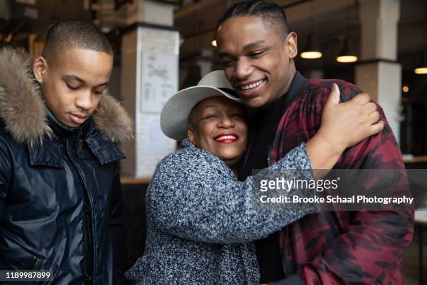 Older Black woman in a cafe having coffee with her sons