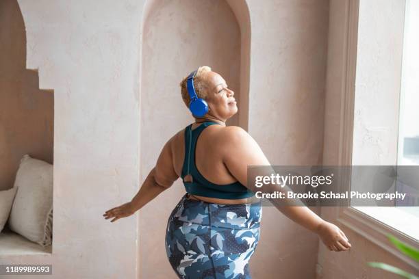 older black woman dancing with headphones on - black woman yoga stock pictures, royalty-free photos & images