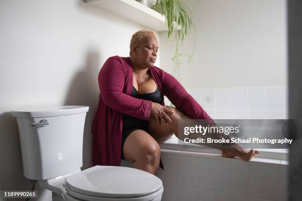 older black woman in bathroom - showus skin stock pictures, royalty-free photos & images