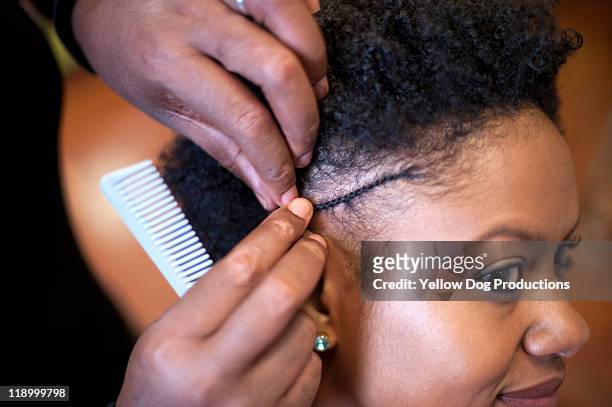 woman getting hair styled at salon - black woman hair stock-fotos und bilder