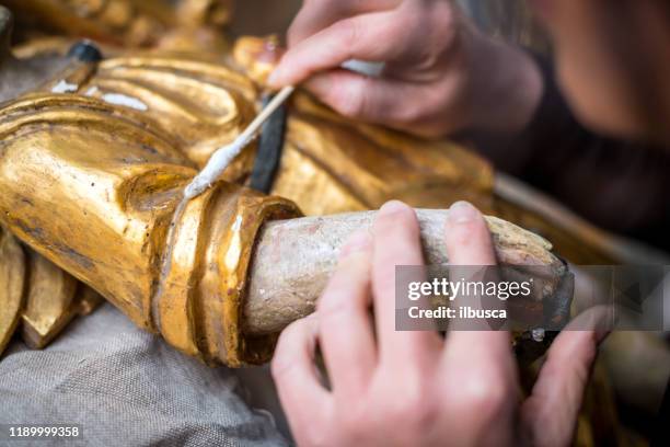 restorer and framer laboratory craftswomen: restoring antique golden angel statue - restoring art stock pictures, royalty-free photos & images