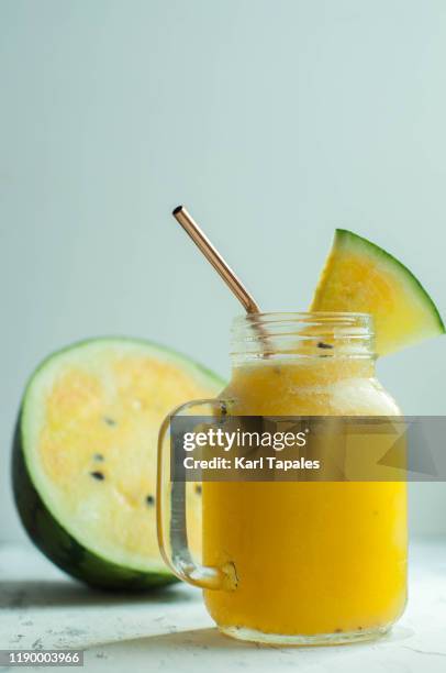 yellow water melon smoothie on a wooden table - yellow smoothie stock pictures, royalty-free photos & images