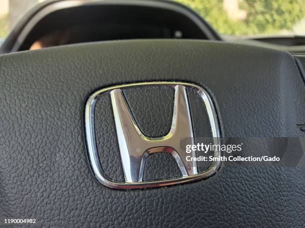 Close-up of logo for Honda automobile company on steering wheel of Honda CRV SUV, Danville, California, August 13, 2019.
