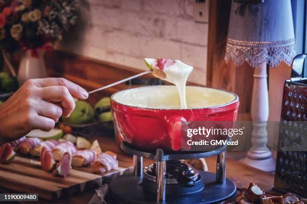 delicious swiss cheese fondue in a pot served with serrano ham - cheese fondue stock pictures, royalty-free photos & images